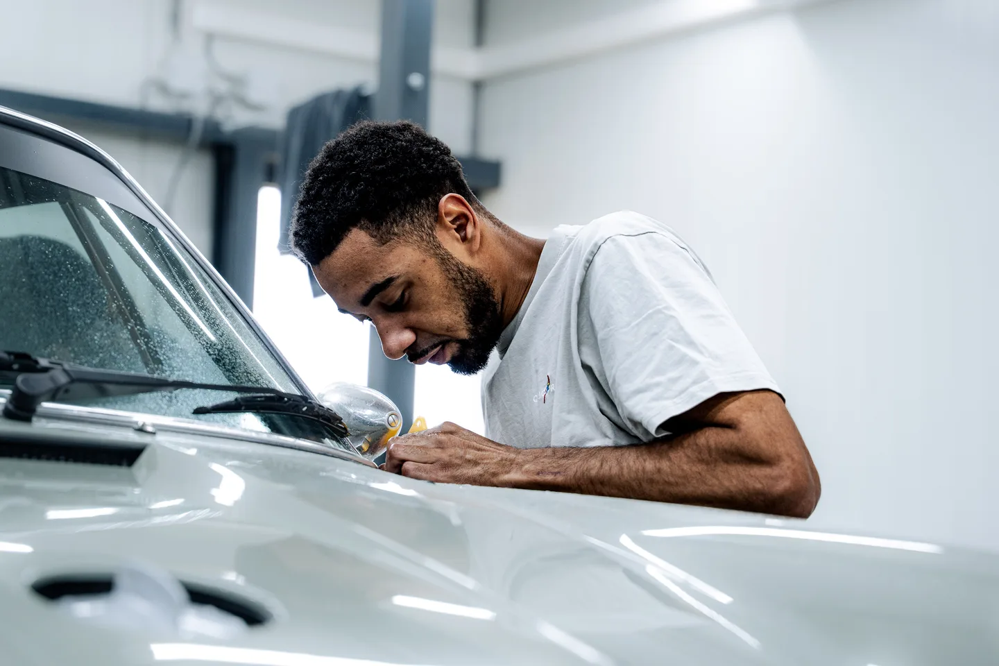 Specialist working on the door of a white car