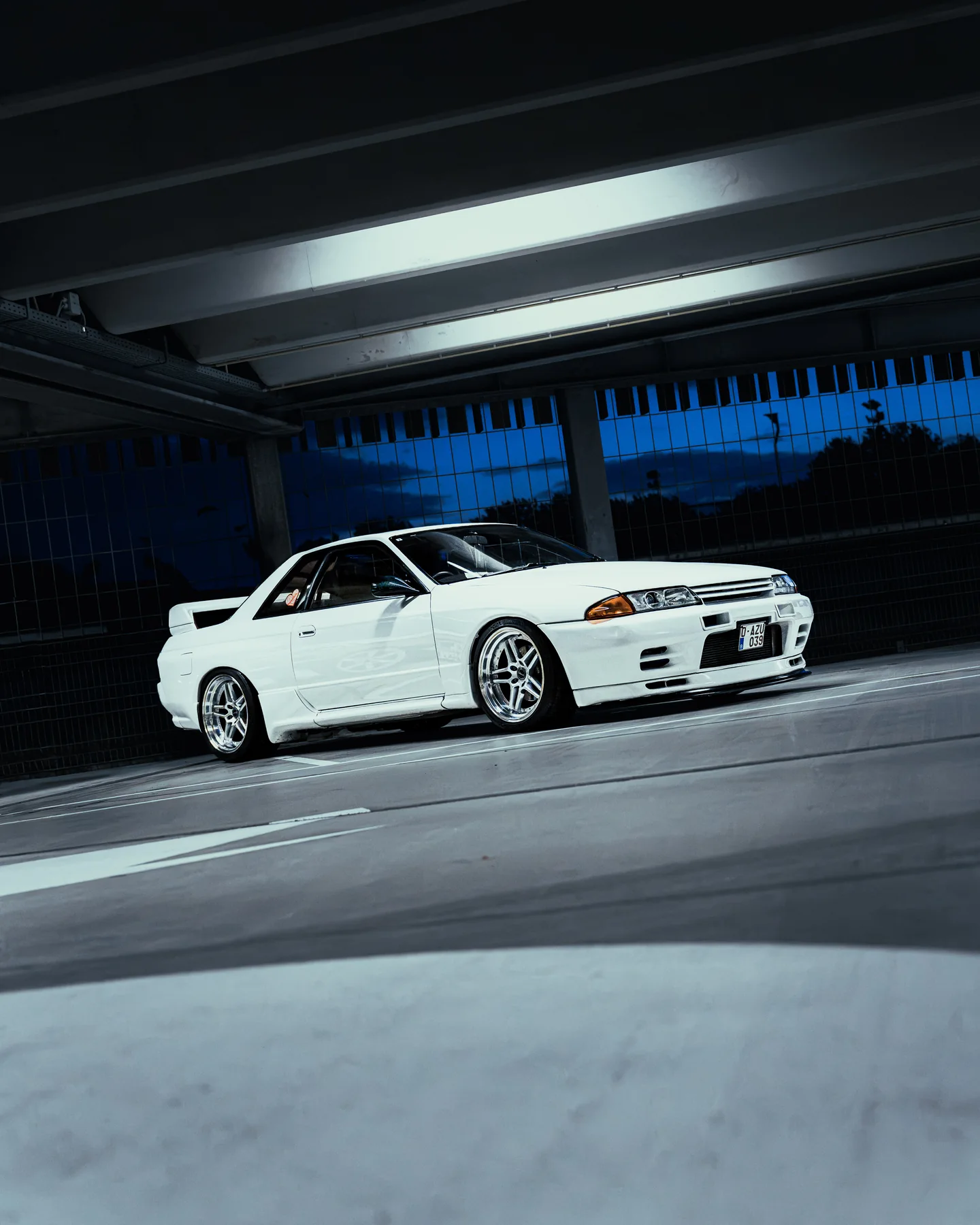 White Japanese sports car inside a parking garage